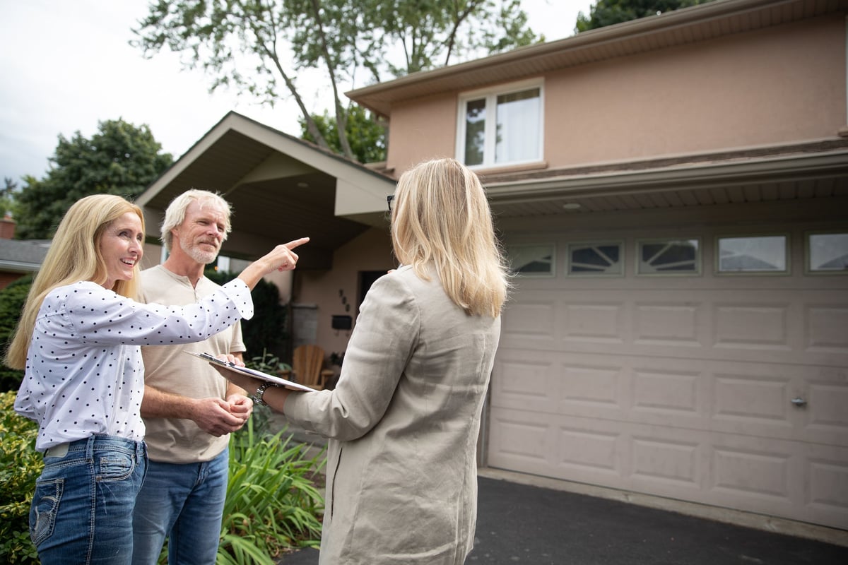 Real estate agent shows mature couple a property.