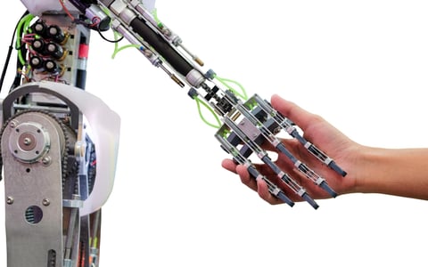 A robot holds a human hand.