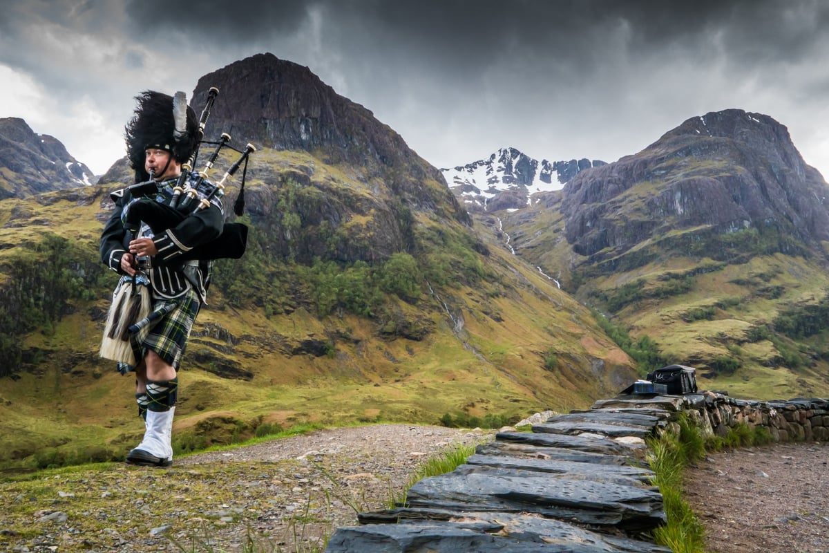 Traditional Scottish bagpiper out in nature.