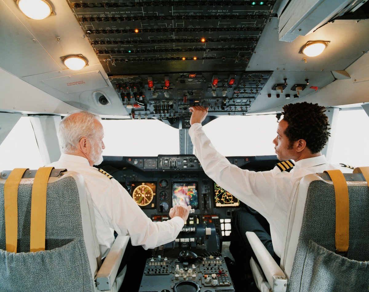 Two pilots sitting in an airplane cockpit.