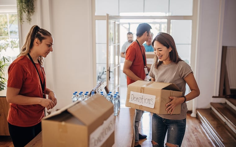 Femme transportant une boîte marquée Dons