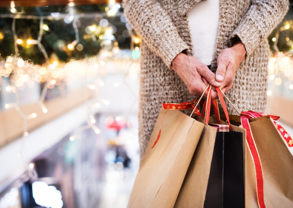 A woman holding shopping bags full of gifts.