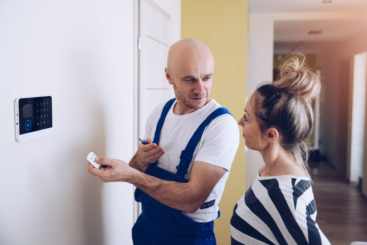 Woman learning how to work home security system