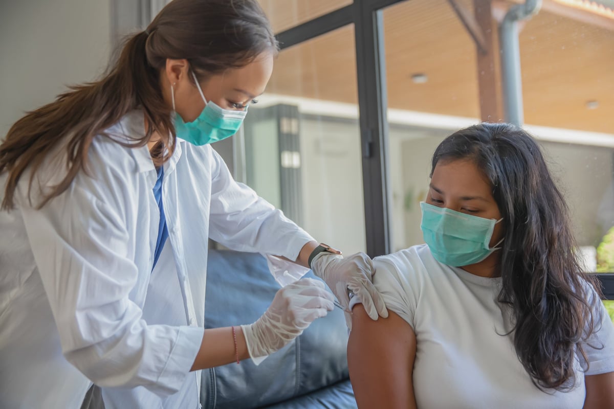 Woman receiving vaccination from a healthcare professional.
