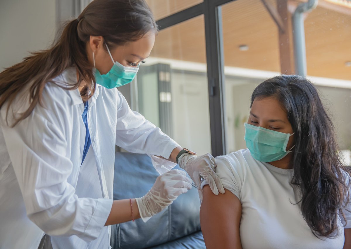 Woman receiving vaccination from a healthcare professional.