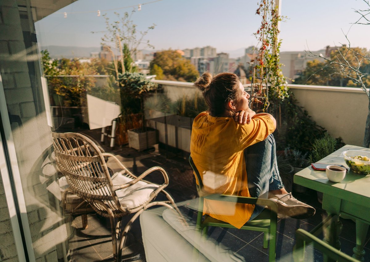 Woman sitting outside on her condo balcony.
