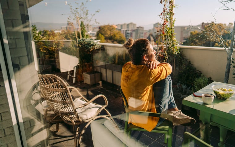 Woman sitting outside on her condo balcony.