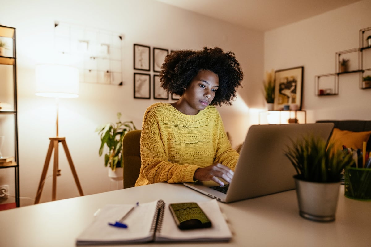 Woman using laptop at home for work or study.