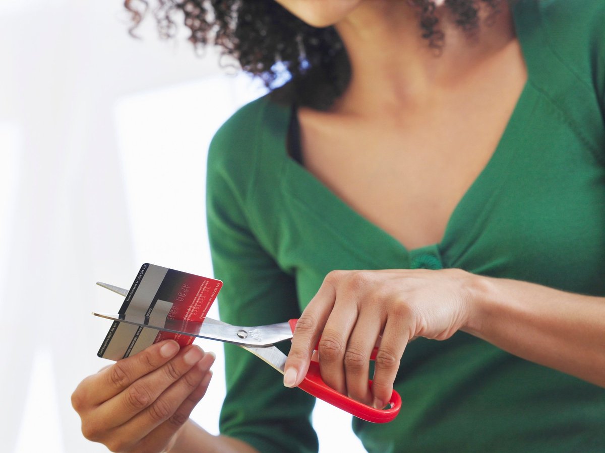 Young Woman Cutting Debit Card With Scissors