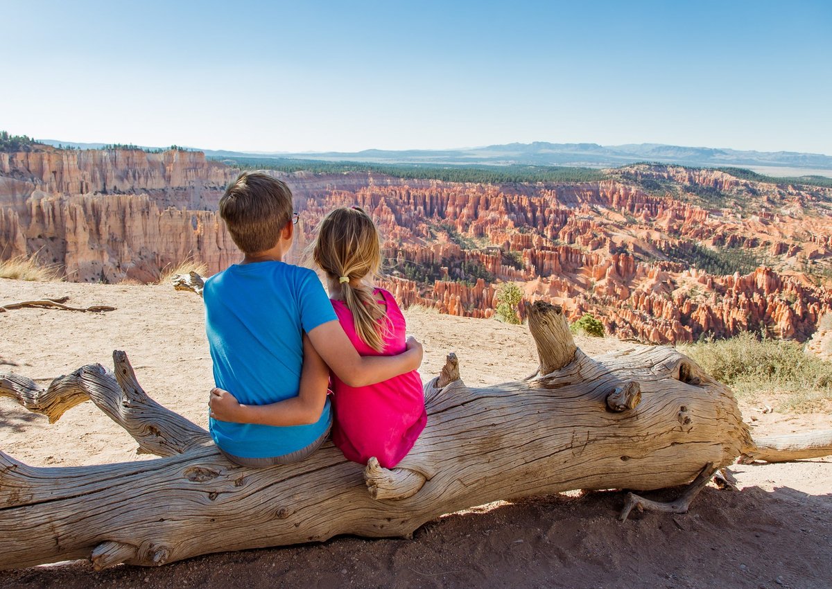 Young boy and girl embrace overlooking Bryce Canyon.
