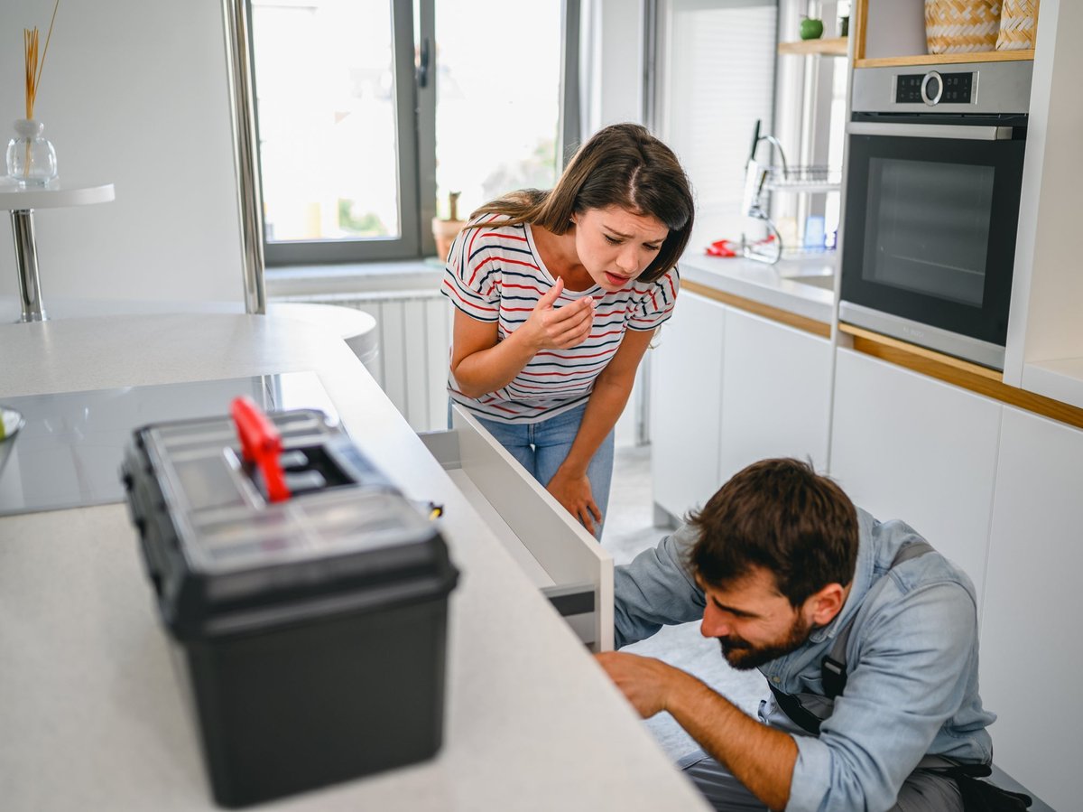 Young couple inspecting drawers with toolbox sitting nearby