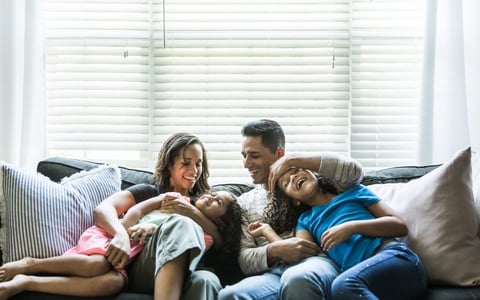 Young family with children spending time together on sofa.