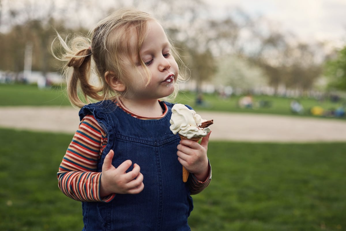 Young girl eating ice cream cone.