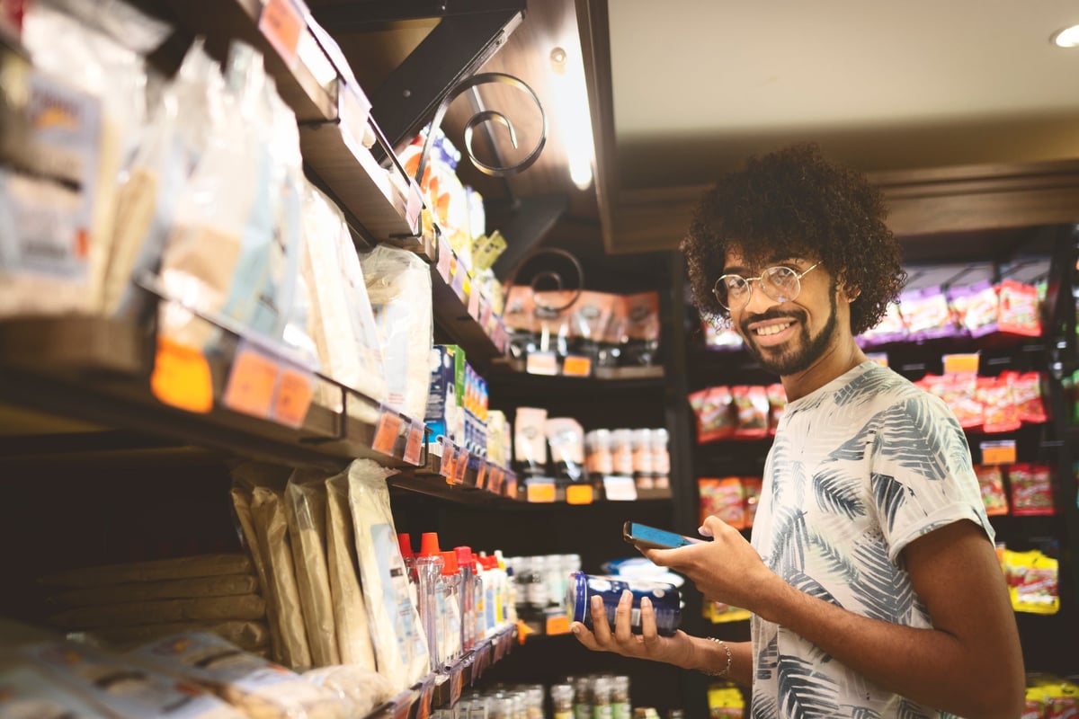 Young man checking prices in supermarket.