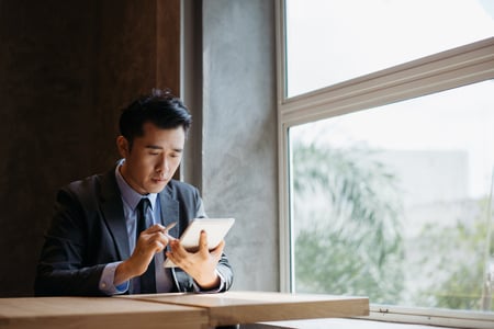 A young businessman uses his tablet to look over his investments.
