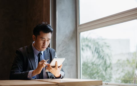 A young businessman uses his tablet to look over his investments.