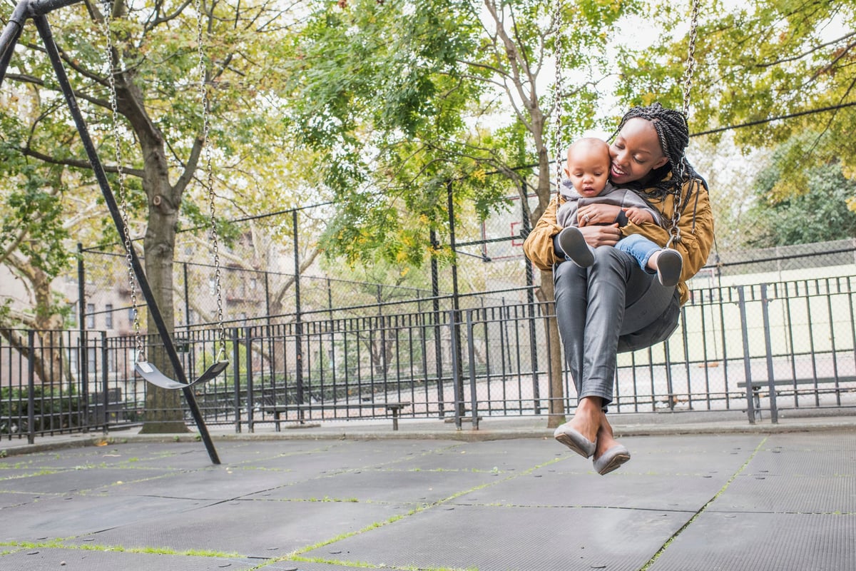 Young mother with infant at city park.