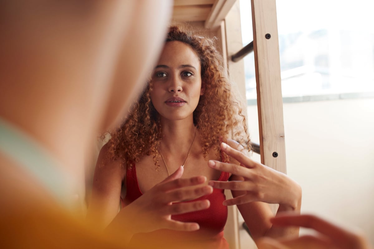 Young woman having serious discussion with another person