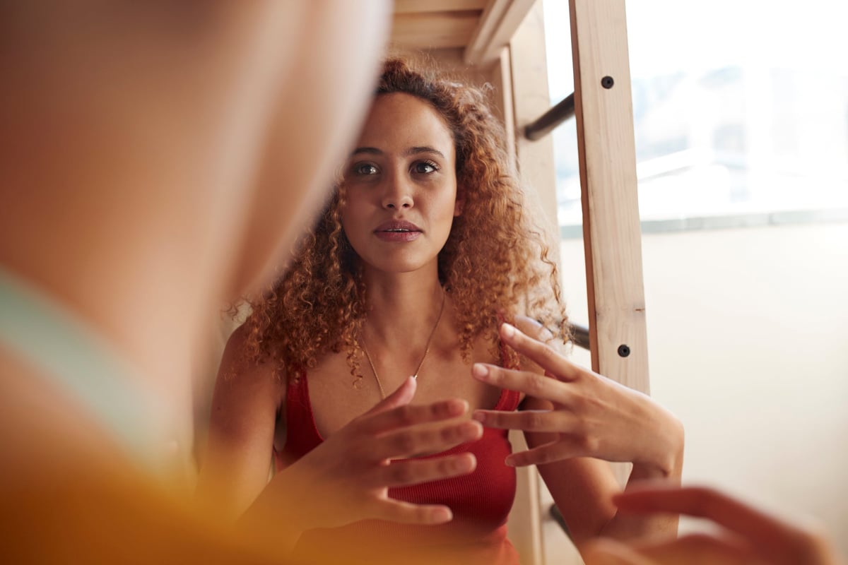 Young woman having serious discussion with another person