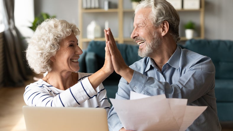A senior couple high-fiving.