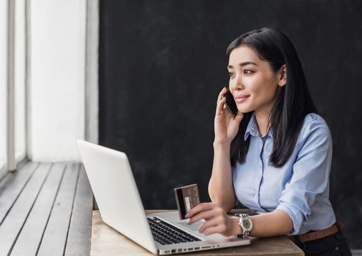 A woman on the phone with a credit card.