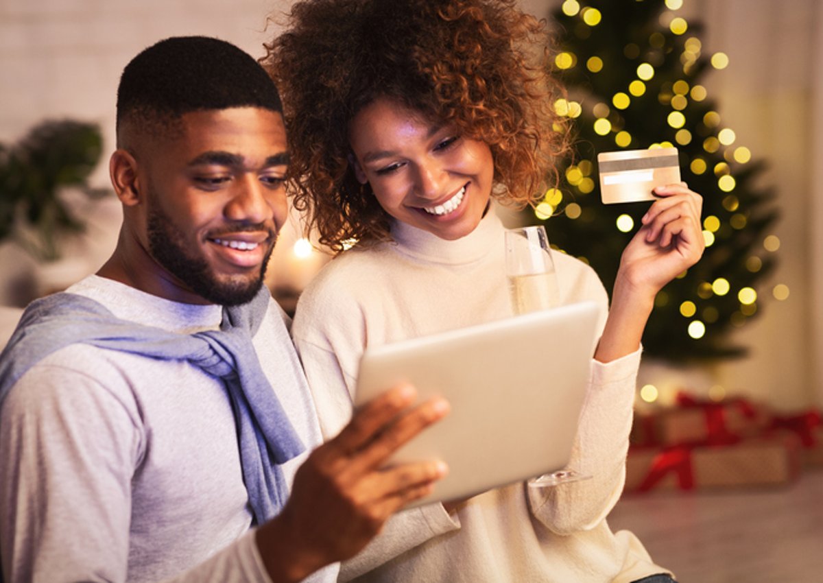Couples shop online with a credit card during the holiday season