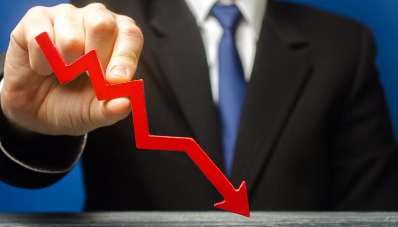 A hand holding a downward graph line.