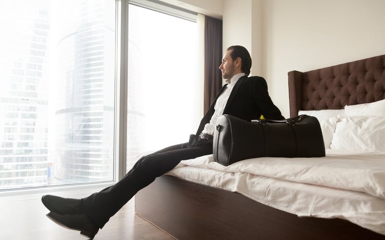 man in suit on hotel bed