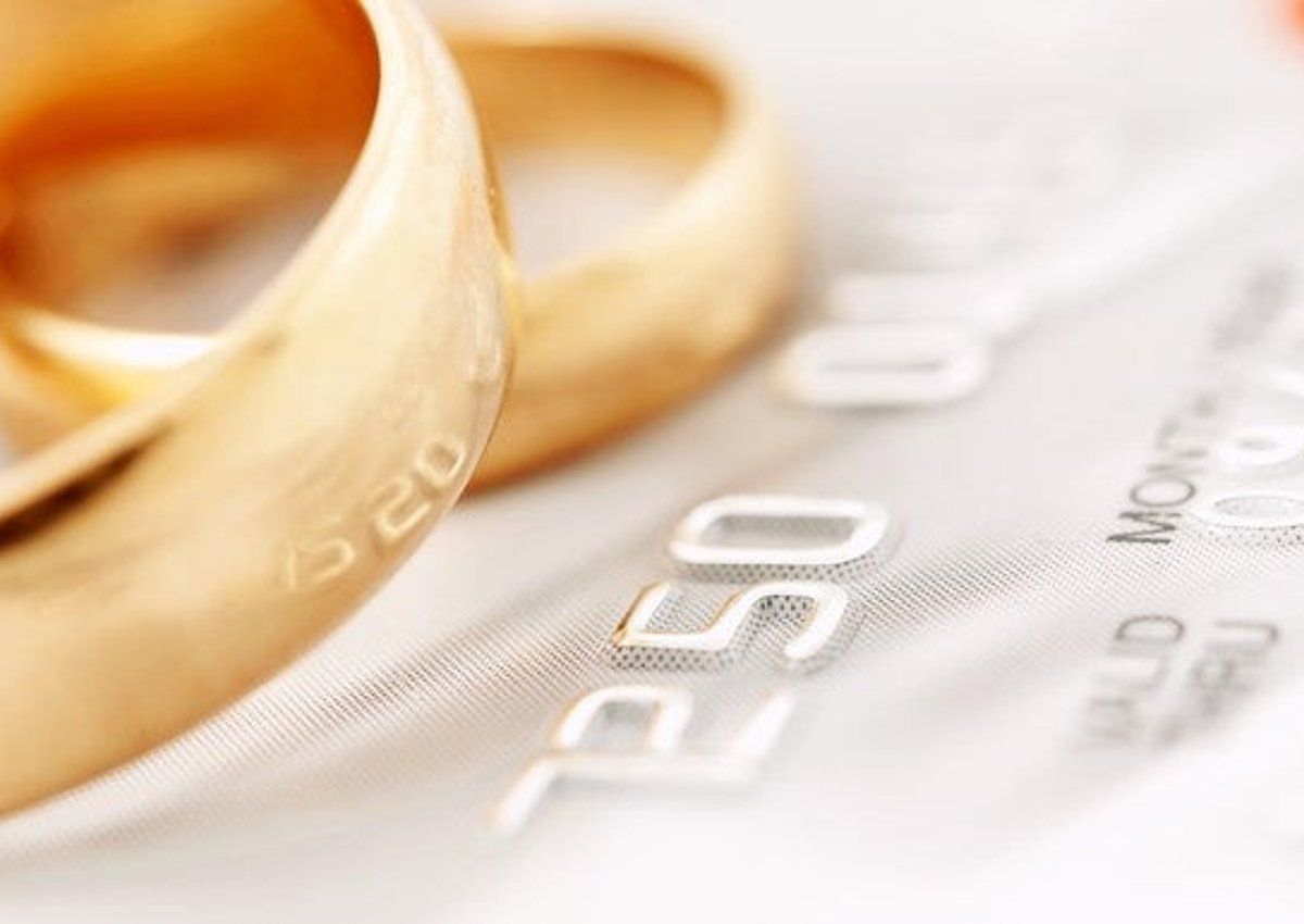 two gold wedding rings resting on a credit card