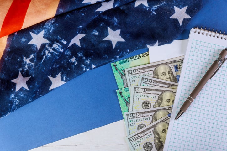 Money and a notepad atop an American flag.
