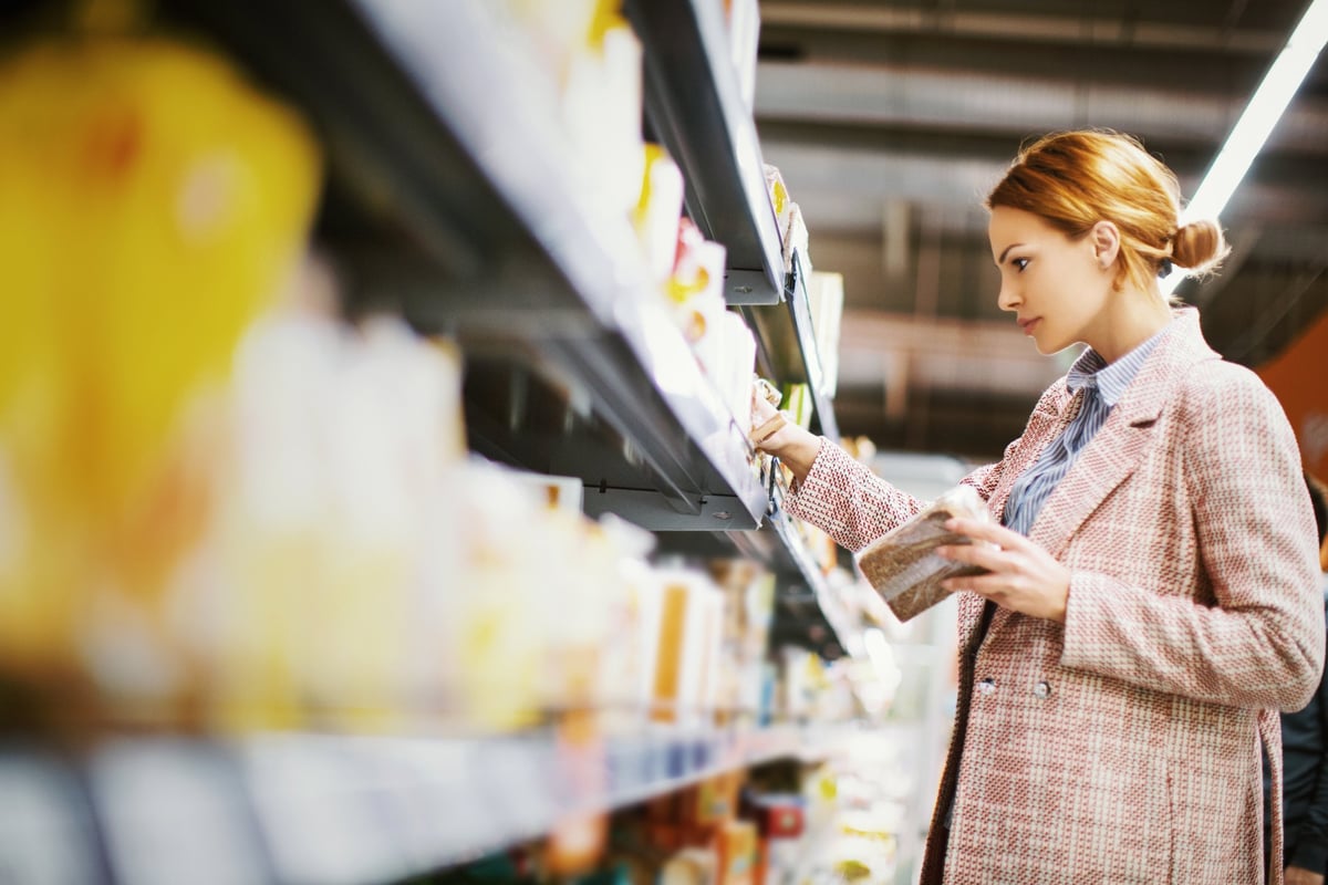 A woman shopping for canned goods at a grocery store.