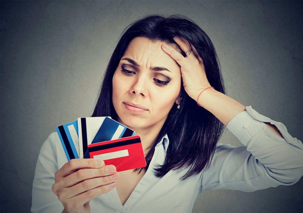 Woman looking at credit cards with confusion. 