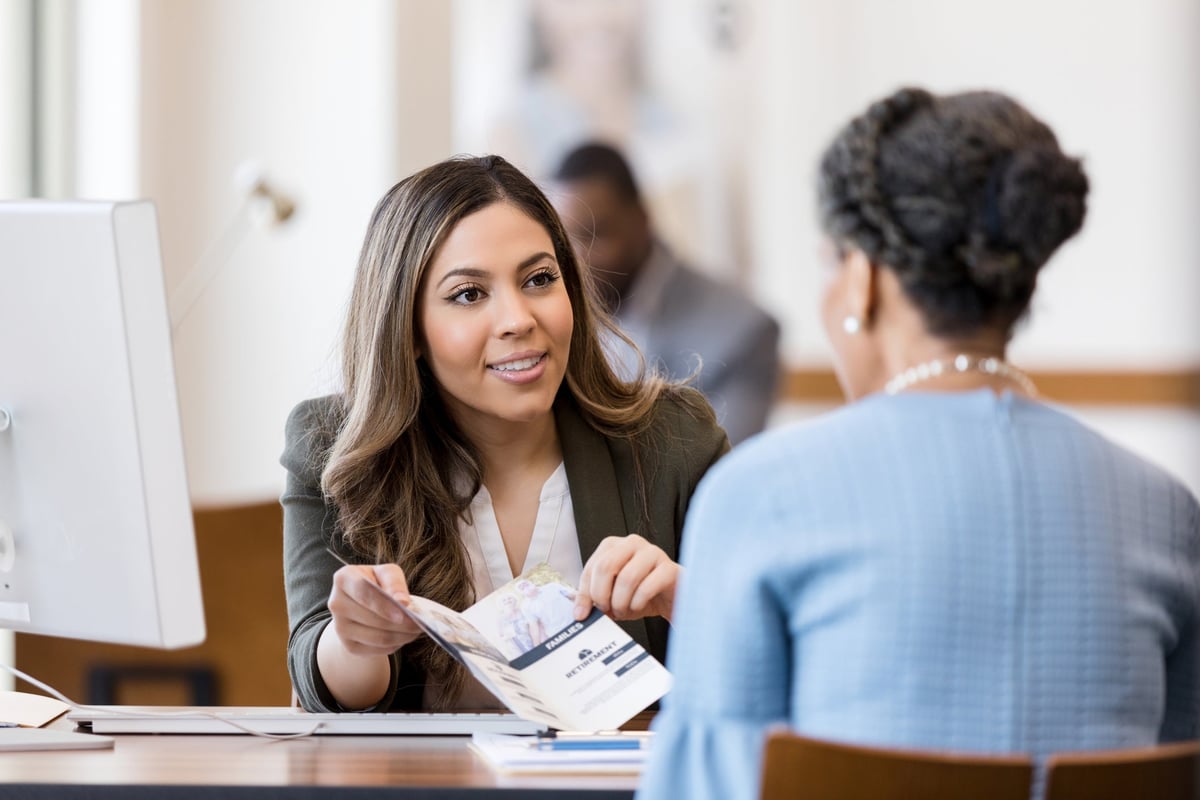 A bank manager is helping a woman open a new account.