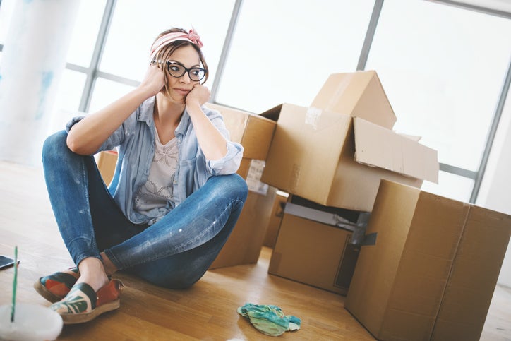 A tired woman with moving boxes.