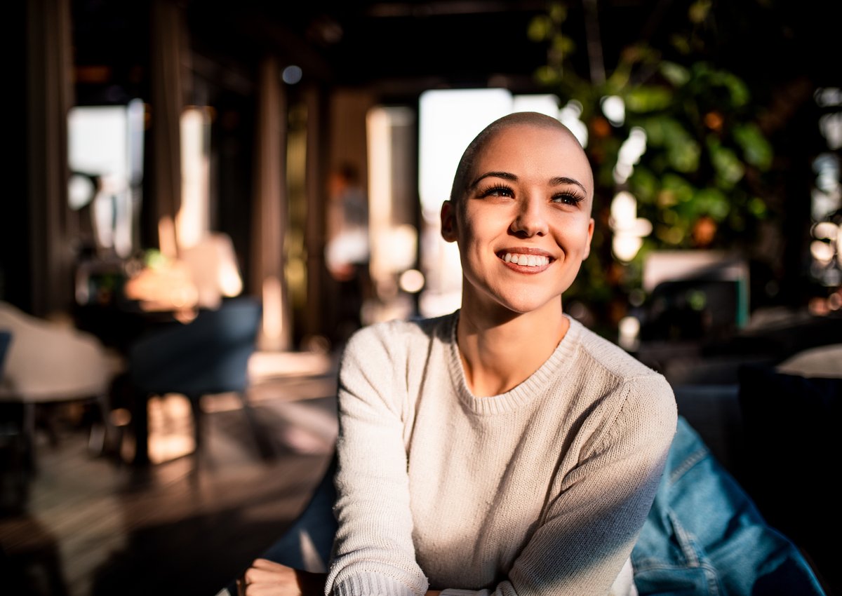 A happy young woman sitting in a sunny room.