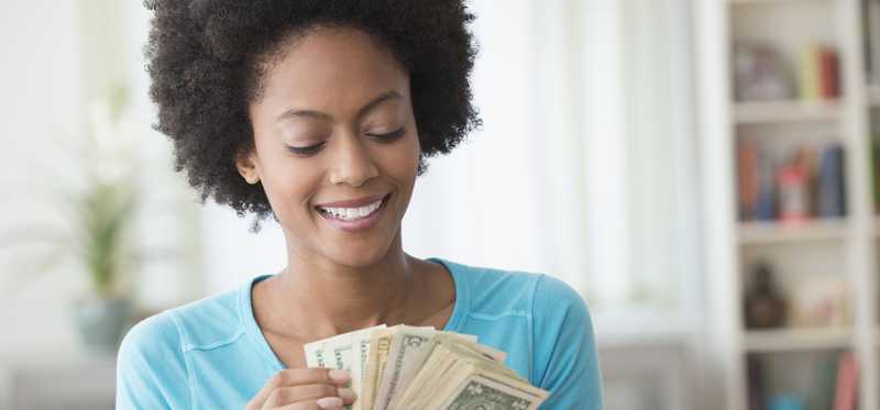 Person holding fanned out bills and counting them.