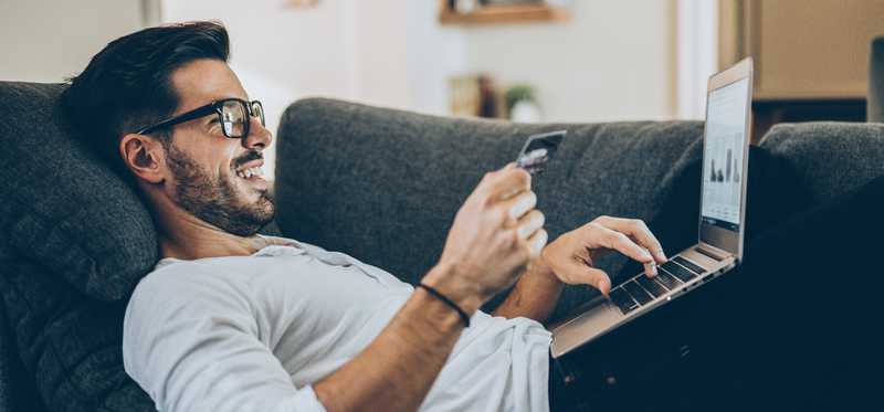 Person lying on couch and shopping online.