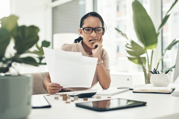 Worried person looking at paperwork in office.