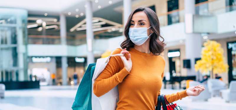 Masked shopper in mall.