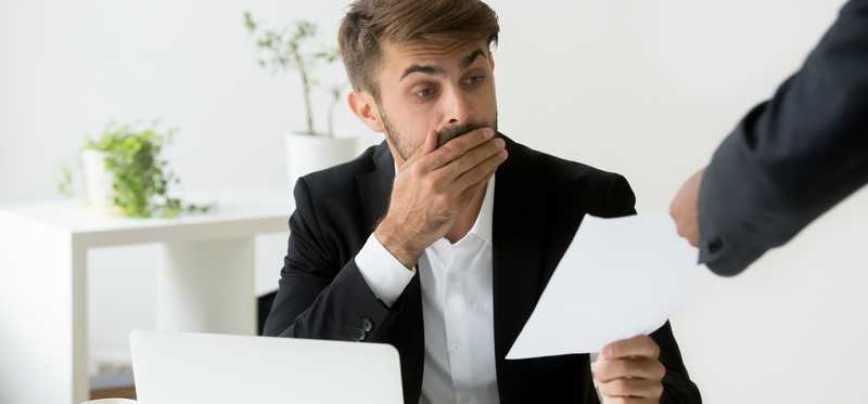 A man looks shocked while receiving report.
