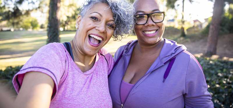Two people smile while taking a selfie.