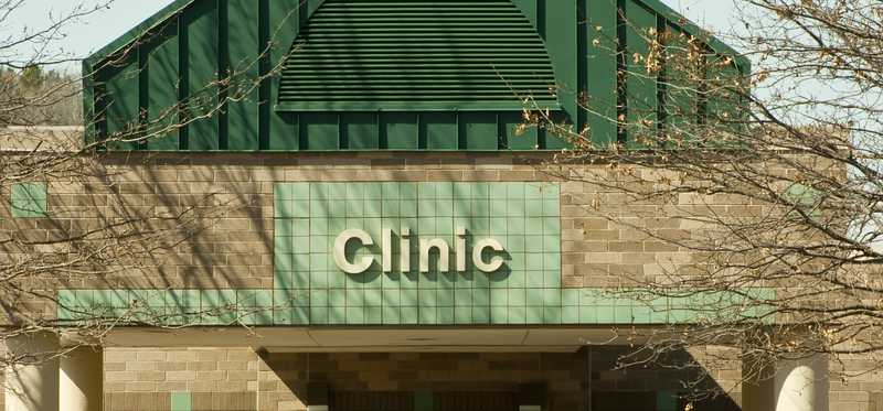 A brick building marked with signage that reads Clinic.