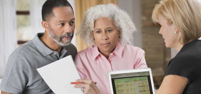 Financial advisor presenting document to two clients.