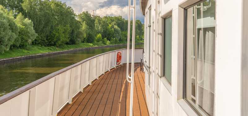 A smallish cruise ship on a river.