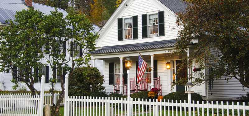 A white house and picket fence in a New Hampshire neighborhood.