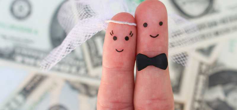 Fingers drawn as husband and wife smiling with dollar bills as backdrop.