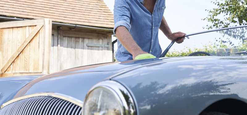 Person posing outside of a classic car.