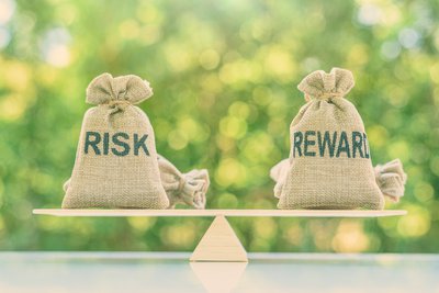 Balanced burlap bags saying Risk Reward.