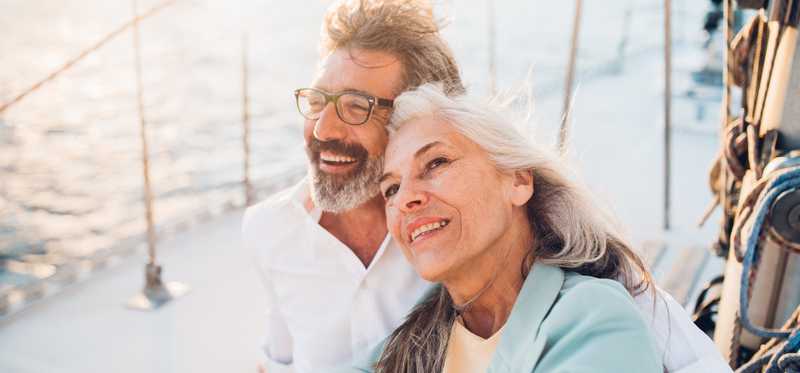 Two people on boat are cuddling and smiling.