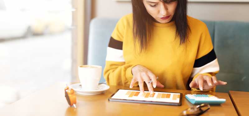 Individual sits at table reviewing charts and using calculator.